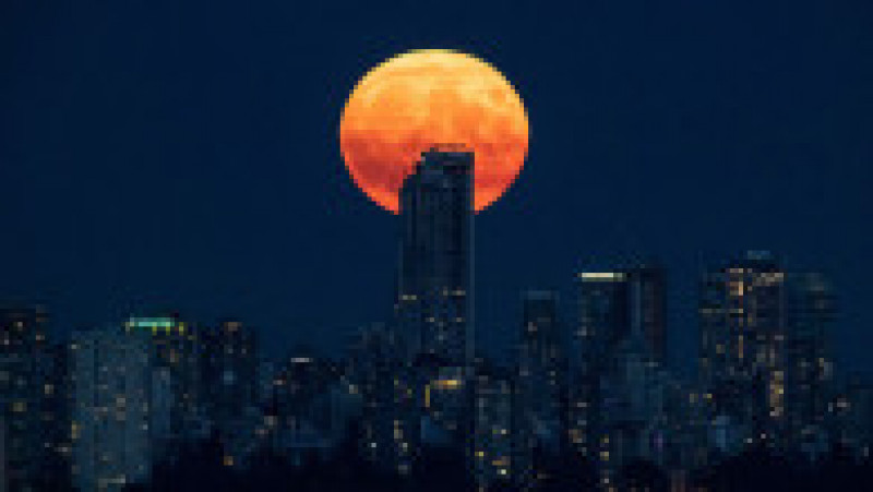 Luna plină de deasupra orașului Vancouver, Canada, are nuanțe portocalii, din cauza inendiilor de begetație. Foto: Profimedia | Poza 6 din 6