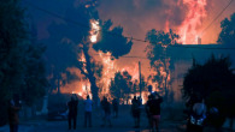 Localnici dintr-o suburbie a Atenei filmează incendiul de vegetație. Foto: Profimedia Images | Poza 41 din 81