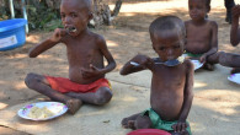 Imagine din 18 mai 2021, când mai mulți copii slăbiți de foame în comuna Sihanamaro, aflată la 30 km de orașul Ambovombe, capitala regiunii Androy din sudul Madagascarului, primesc o masă caldă din partea ofițerilor Programului alimentar mondial al ONU. Sursă foto: ©Krystyna Kovalenko/The UN