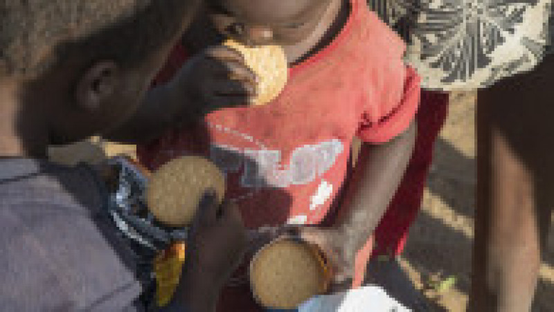 Imagine sugestivă cu doi frați din Africa, care mănâncă pentru prima dată biscuiți cu ciocolată. Sursă foto: Getty Images | Poza 12 din 81
