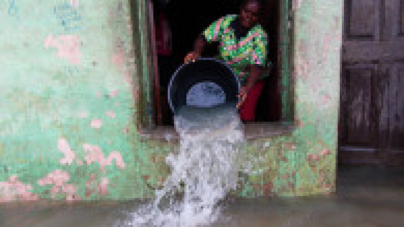 O femeie încearcă să scoată apa din casa sa inundată. Foto din 2020: Profimedia Images | Poza 5 din 5