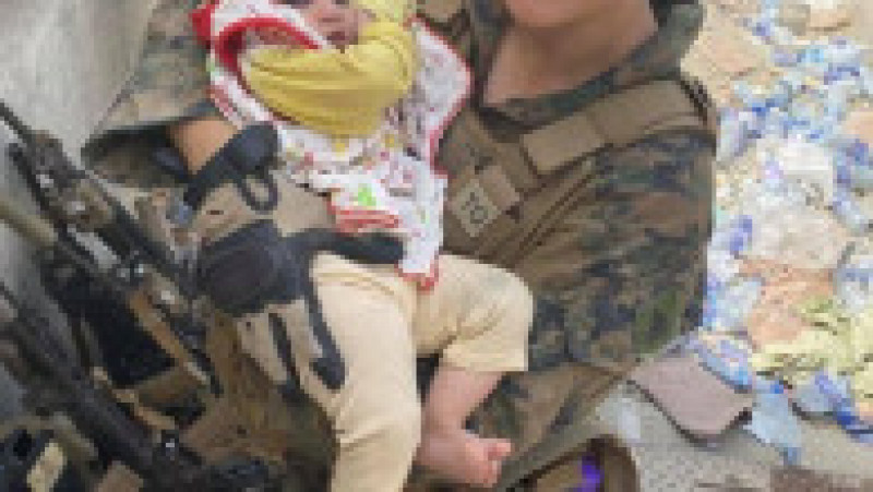 Nicole Gee ținând un bebeluș afgan în brațe, pe aeroportul din Kabul. Foto: Facebook | Poza 1 din 5