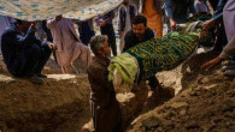 Trupul lui Mushtaq, învelit în pături, este coborât în groapă. Foto: Profimedia | Poza 7 din 8
