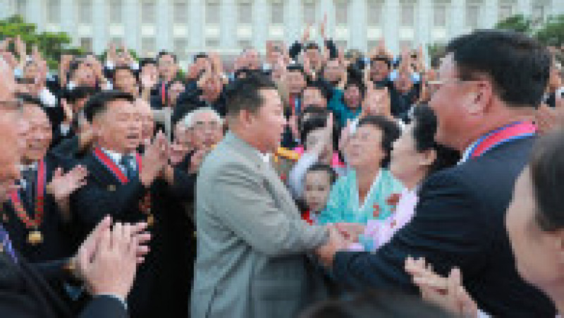 Fotografie de propagandă cu dictatorul nord-coreean salutând oameni dintr-o mulțime. Foto: Profimedia Images | Poza 13 din 14