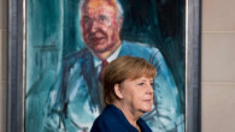 Angela Merkel trece pe lângă un portret al mentorului ei în politică, fostul cancelar Helmut Kohl Foto: Profimedia Imagers | Poza 8 din 41