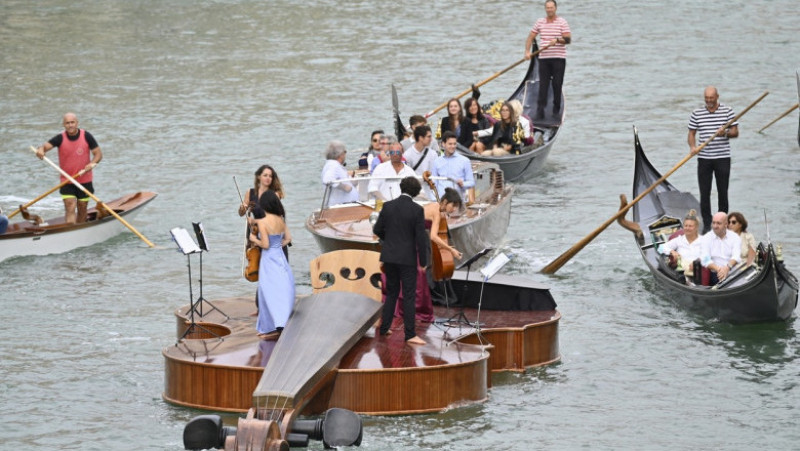 Un cvartet interpretează Vivaldi pe o barcă gigantică în formă de vioară, pe canalele Venetiei. Foto: Profimedia Images