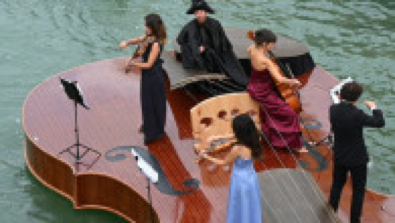 Un cvartet interpretează Vivaldi pe o barcă gigantică în formă de vioară, pe canalele Venetiei. Foto: Profimedia Images | Poza 4 din 9