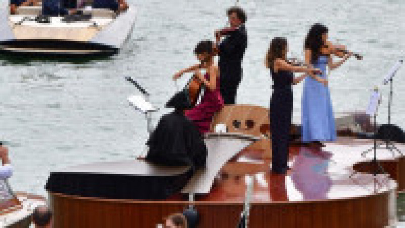 Un cvartet interpretează Vivaldi pe o barcă gigantică în formă de vioară, pe canalele Venetiei. Foto: Profimedia Images | Poza 9 din 9