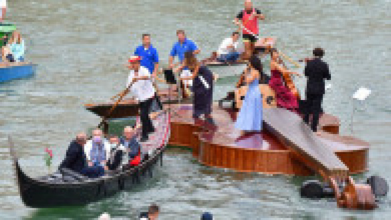 Un cvartet interpretează Vivaldi pe o barcă gigantică în formă de vioară, pe canalele Veneției. Foto: Profimedia Images | Poza 8 din 9