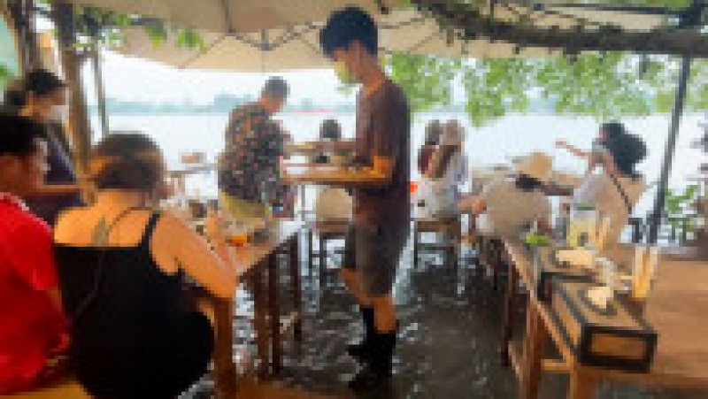 Restaurantul lui Titiporn atrage turiști pe bandă rulantă, care preferă să stea la masă cu picioarele în apă. FOTO: Profimedia Images | Poza 15 din 16
