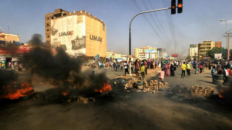 Oamenii au incendiat cauciuri pe străzile capitalei Sudanului după arestarea membrilor guvernului civil al țării. Foto: Profimedia Images
