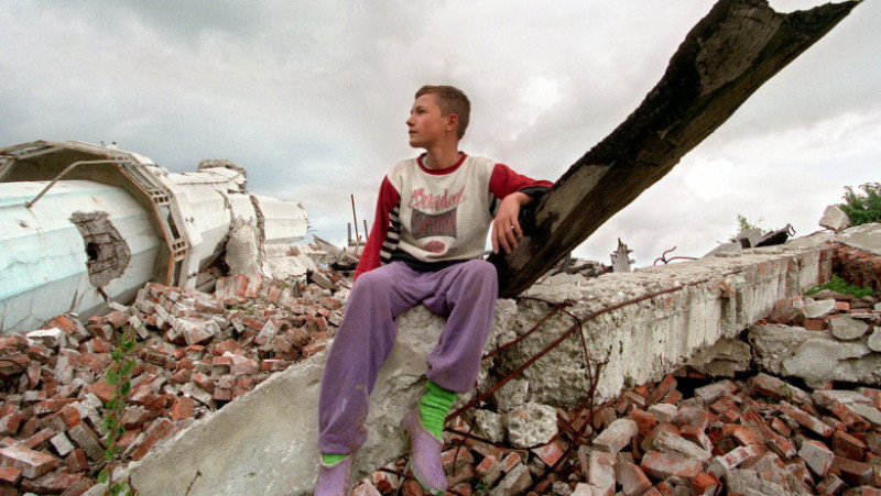 Un băiat musulman stă pe ruinele unei moschei din Bosnia, mai 1996. Sursa foto: AFP PHOTO / ODD ANDERSEN / Profimedia Images