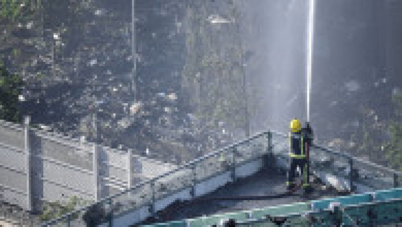 LONDON, ENGLAND - JUNE 14: A fire fighter tackles the building after a huge fire engulfed the 24 story Grenfell Tower in Latimer Road, West London in the early hours of this morning on June 14, 2017 in London, England. The Mayor of London, Sadiq Khan, has declared the fire a major incident as more than 200 firefighters are still tackling the blaze, while at least 50 people are receiving hospital treatment. (Photo by Leon Neal/Getty Images) | Poza 4 din 13