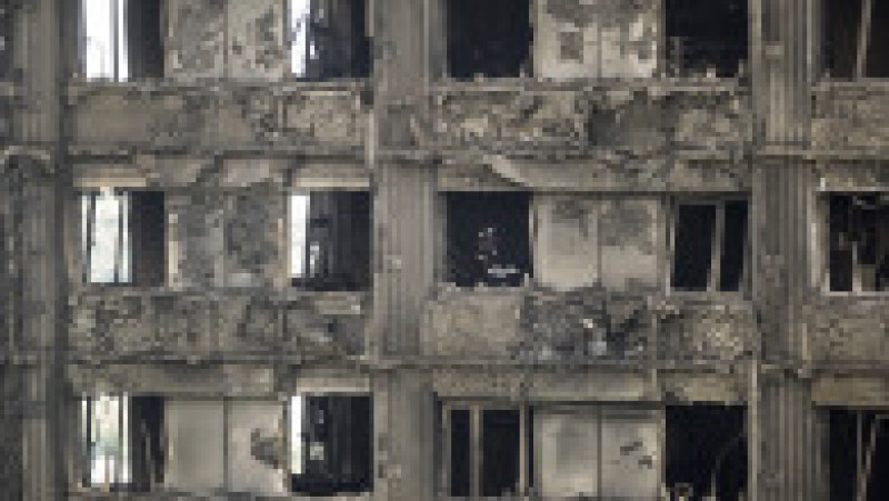 LONDON, ENGLAND - JUNE 15: Firefighters inspect the blackened interior of Grenfell Tower on June 15, 2017 in London, England. At least 17 people have been confirmed dead and dozens missing, after the 24 storey residential Grenfell Tower block in Latimer Road was engulfed in flames in the early hours of June 14. The number of fatalities are expected to rise. (Photo by Dan Kitwood/Getty Images) | Poza 13 din 13