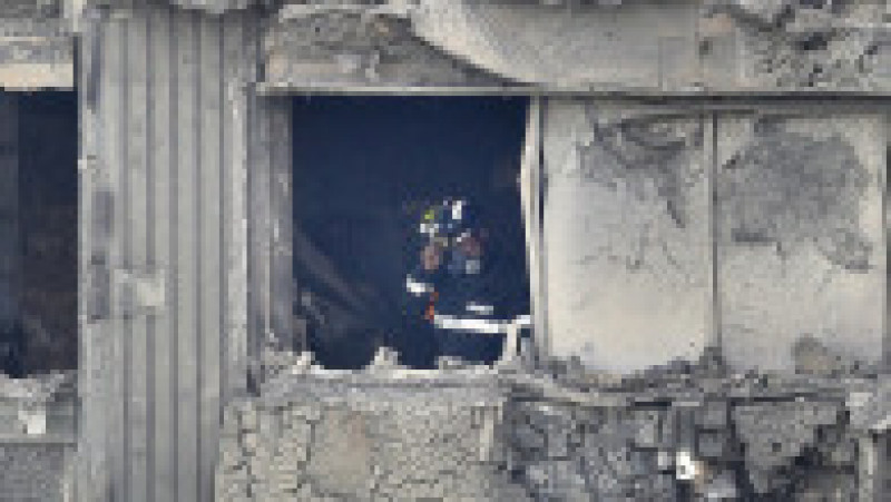 LONDON, ENGLAND - JUNE 15: A firefighter conducts a search of burned out flat in Grenfell Tower on June 15, 2017 in London, England. At least 17 people have been confirmed dead and dozens missing, after the 24 storey residential Grenfell Tower block in Latimer Road was engulfed in flames in the early hours of June 14. The number of fatalities are expected to rise. (Photo by Dan Kitwood/Getty Images) | Poza 12 din 13
