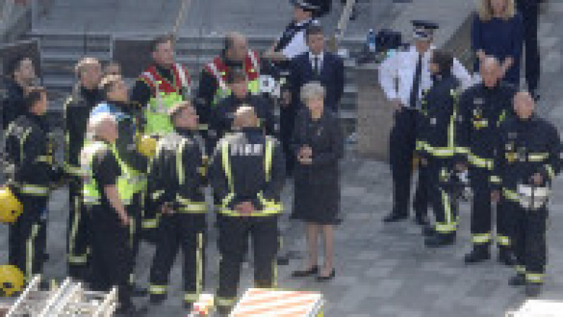 LONDON, ENGLAND - JUNE 15: Prime Minister Theresa May speaks to Dany Cotton, Commissioner of the London Fire Brigade, with members of the fire service as she visits Grenfell Tower, on June 15, 2017 in London, England. At least twelve people have been confirmed dead and dozens missing, after the 24 storey residential Grenfell Tower block in Latimer Road was engulfed in flames in the early hours of June 14. The number of fatalities are expected to rise. (Photo by Dan Kitwood/Getty Images) | Poza 9 din 13
