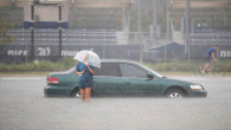HOUSTON, TX - AUGUST 27: Mari Zertuche walks through a flooded parking lot on the campus of Rice University afer it was inundated with water from Hurricane Harvey on August 27, 2017 in Houston, Texas. Harvey, which made landfall north of Corpus Christi late Friday evening, is expected to dump upwards to 40 inches of rain in areas of Texas over the next couple of days. (Photo by Scott Olson/Getty Images) | Poza 5 din 15