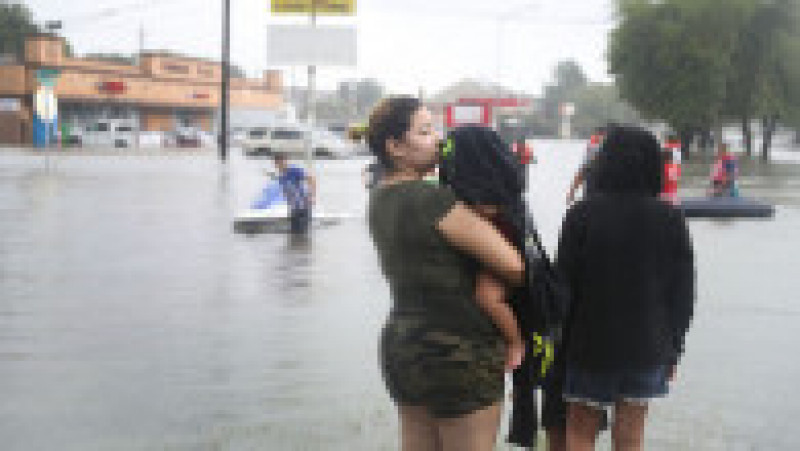 HOUSTON, TX - AUGUST 27: People walk down a flooded street as they evacuate their homes after the area was inundated with flooding from Hurricane Harvey on August 27, 2017 in Houston, Texas. Harvey, which made landfall north of Corpus Christi late Friday evening, is expected to dump upwards to 40 inches of rain in Texas over the next couple of days. (Photo by Joe Raedle/Getty Images) | Poza 2 din 15