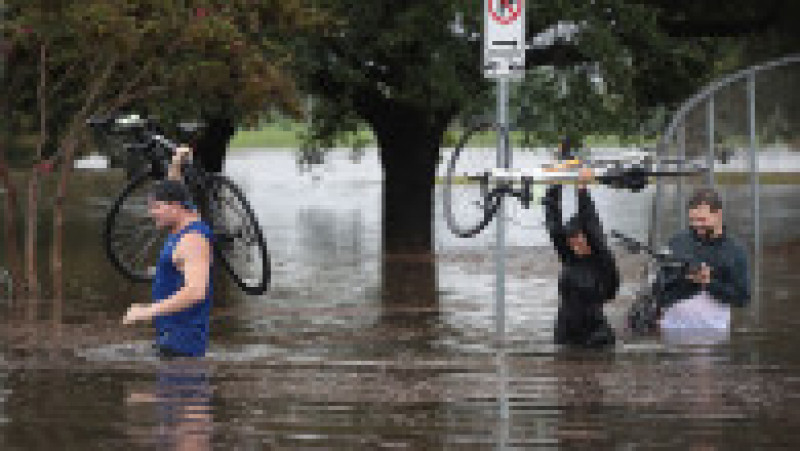 HOUSTON, TX - AUGUST 27: Residents navigate a flooded street that has been inundated with water from Hurricane Harvey on August 27, 2017 in Houston, Texas. Harvey, which made landfall north of Corpus Christi late Friday evening, is expected to dump upwards to 40 inches of rain in areas of Texas over the next couple of days. (Photo by Scott Olson/Getty Images) | Poza 4 din 15