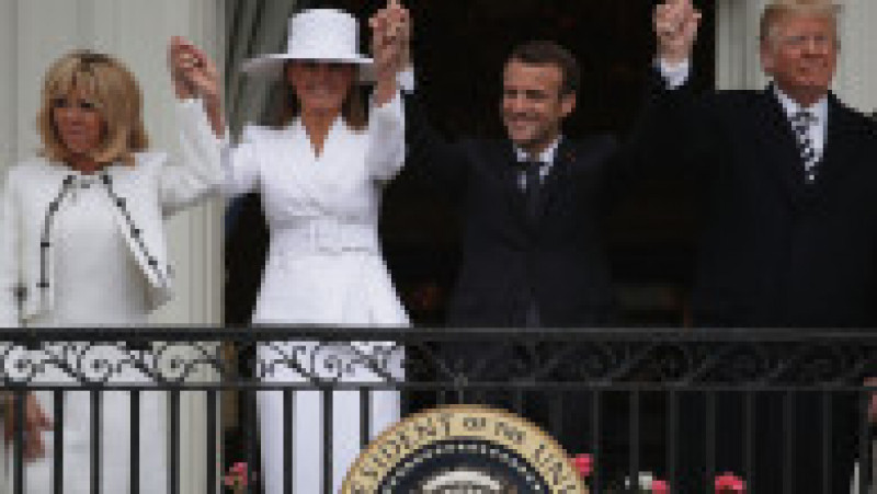 WASHINGTON, DC - APRIL 24: U.S. President Donald Trump (R) and first lady Melania Trump (2nd L), French President Emmanuel Macron (3rd L) and his wife Brigitte Macron (L) hold up their hands during a state arrival ceremony at the White House April 24, 2018 in Washington, DC. Trump is hosting Macron for a two-day official visit that includes dinner at George Washington