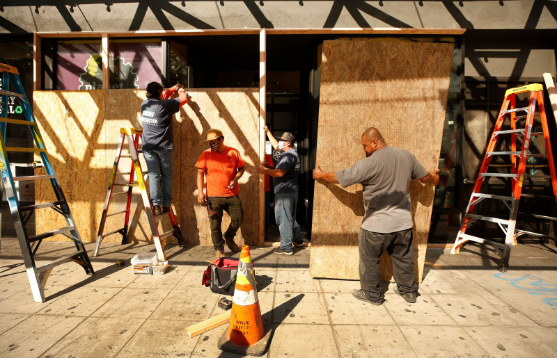 muncitori din los angeles acopera cu lemn vitrinele unui magazin