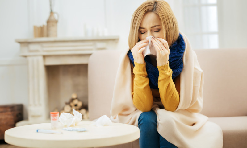 Young blond woman having fever and running nose
