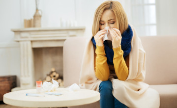 Young blond woman having fever and running nose