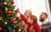 happy family mother, father and child daughter decorate Christmas tree
