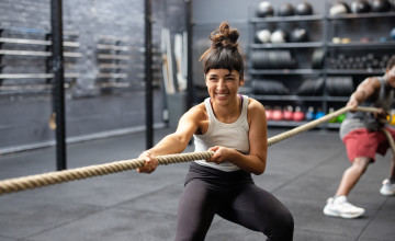 Group of fitness people playing tug of war at a cross training gym