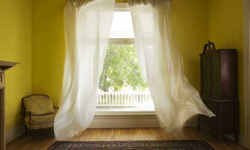 Room with curtains billowing at open window